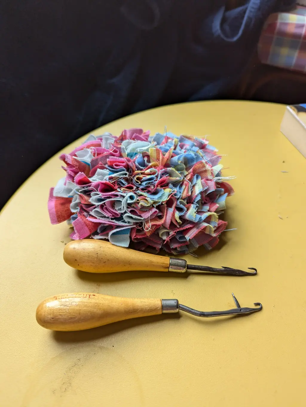 picture of a small rag rug and two latch hooks