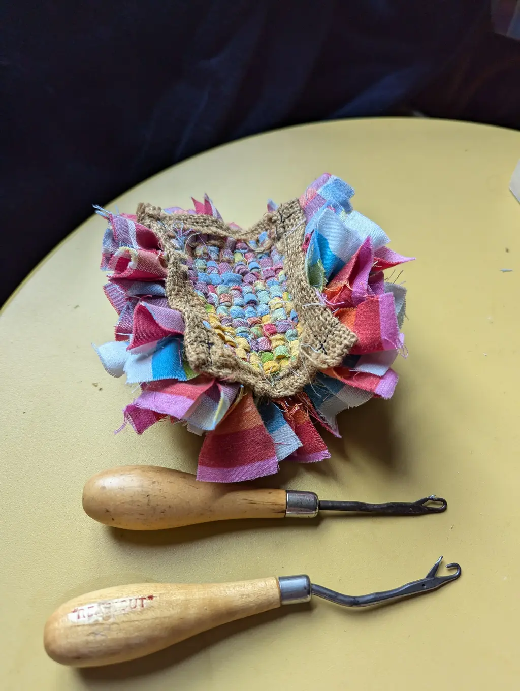 picture of bottom of a small rag rug and two latch hooks