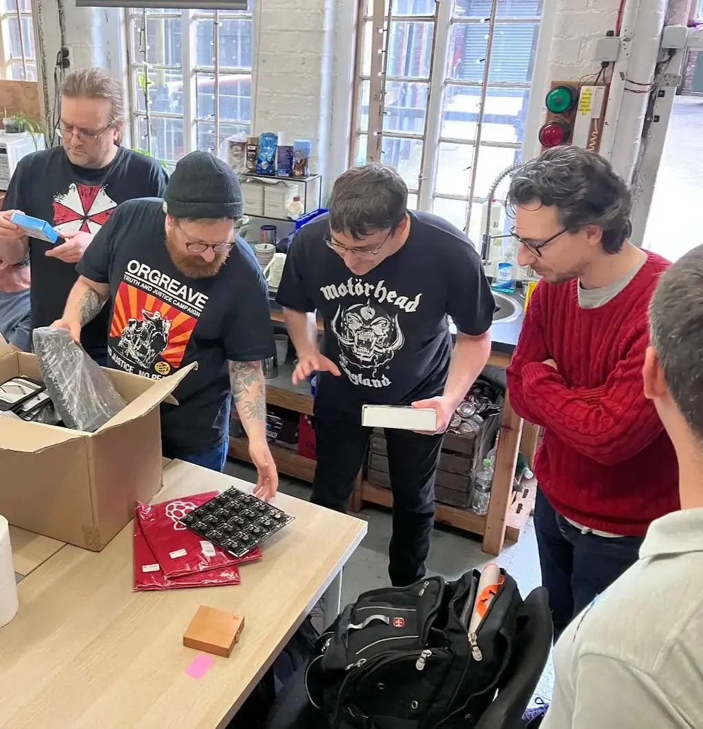 picture of several people looking at electronic items in cardboard box