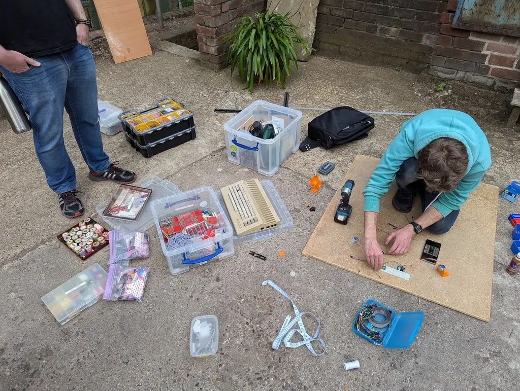 picture of one person setting up electronics on a vertical wooden board