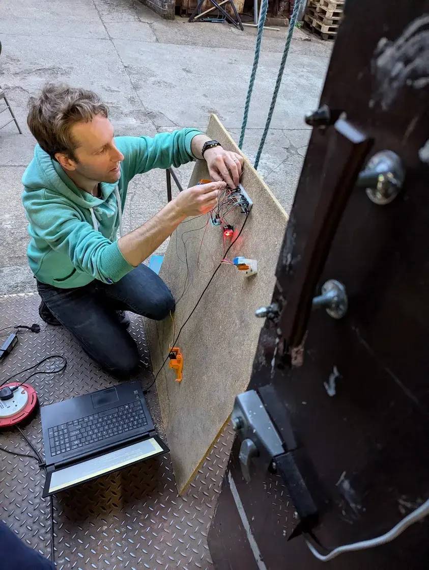 picture of one person setting up electronics on the floor outside