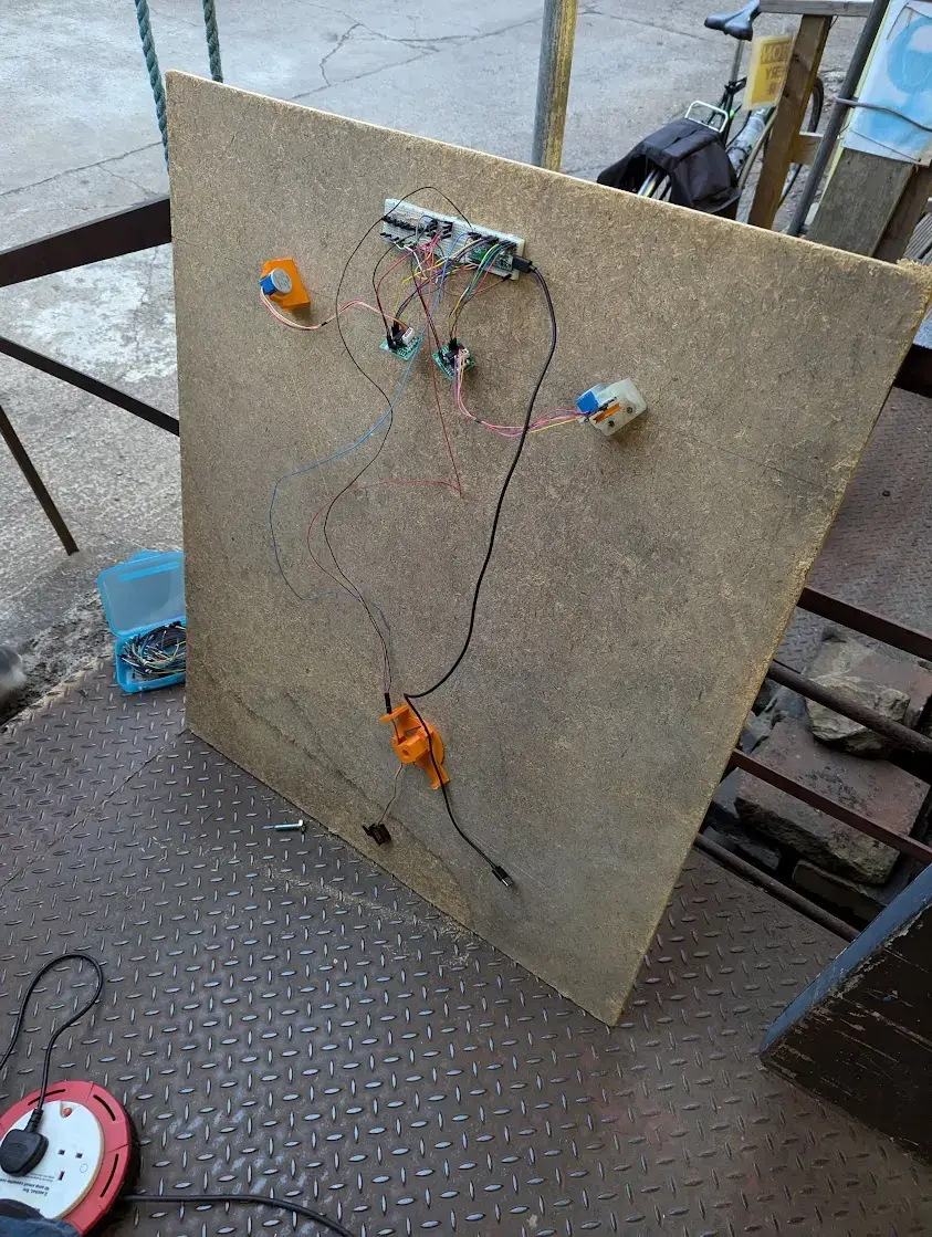 picture of a vertical pen plotter, i.e., an upright wooden board with two motors attached, and a pulley system with caddy