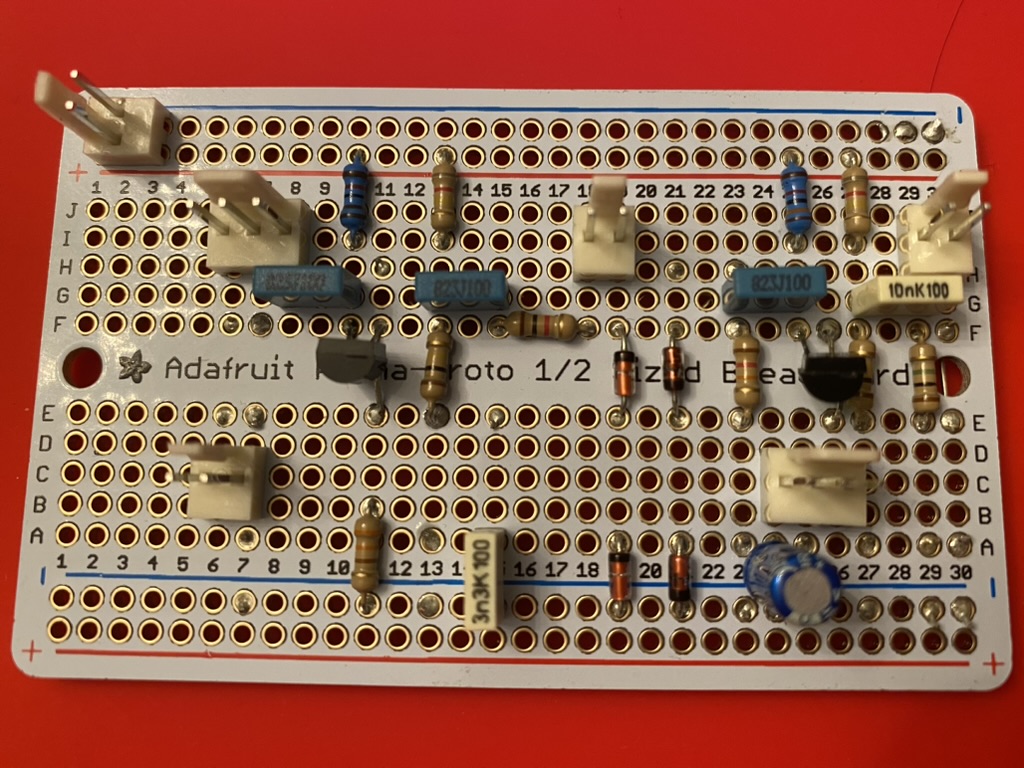 Picture of electronics board, with several components soldered to it. The name "Adafruit" is visible.